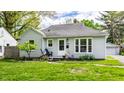 Lovely one-story house with well-kept lawn, landscaping, detached garage and cozy front entrance at 5643 Rosslyn Ave, Indianapolis, IN 46220