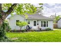 Charming single-story house featuring a well-kept lawn, fresh landscaping, and covered front porch at 5643 Rosslyn Ave, Indianapolis, IN 46220