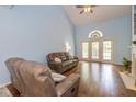 Comfortable living room featuring hardwood floors, high ceilings, and a large window with French doors at 5744 Spruce Knoll Ct, Indianapolis, IN 46220