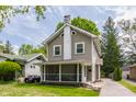 Attractive two-story home with a screened front porch and well-maintained landscaping at 5829 Broadway St, Indianapolis, IN 46220