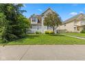 Traditional home with lush green lawn, mature trees, and walkway leading to the entrance at 608 East 21St St, Indianapolis, IN 46202