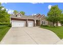 Beautiful home featuring a stone facade, red siding, two-car garage, and long driveway at 6150 Rolling Rock Ln, Noblesville, IN 46062