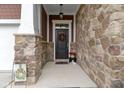 Inviting front porch with stone accents, a decorative wreath, and a welcoming ambiance at 6150 Rolling Rock Ln, Noblesville, IN 46062