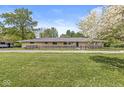 Well-maintained single-story home with a stone facade, black fence, and manicured lawn, ready to move in at 6464 Whitley Ln, Indianapolis, IN 46260