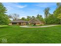 An impressive single story home with circle drive and three car detached garage on a landscaped lawn at 6465 Lawrence Dr, Indianapolis, IN 46226