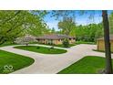 An impressive single story home with circle drive and extensive concrete parking area on a landscaped lawn at 6465 Lawrence Dr, Indianapolis, IN 46226