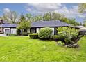 Well-maintained front yard with lush green grass, and an attached garage at 7245 Highburry Dr, Indianapolis, IN 46256