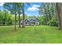 A two-story house on a large lot surrounded by tall, mature trees and a green lawn at 7716 Traders Hollow Ln, Indianapolis, IN 46278