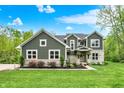 Attractive front of home featuring a well-kept lawn, stone accents and mature landscaping at 7716 Traders Hollow Ln, Indianapolis, IN 46278