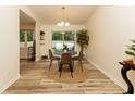 Bright dining area with backyard views, wood-look floors, and modern light fixture at 780 Wilson Terrace Ct, Carmel, IN 46032