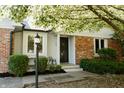Home exterior boasts a cozy front porch with brick detail, decorative lamp, and manicured landscaping at 780 Wilson Terrace Ct, Carmel, IN 46032