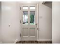 Inviting entryway features a neutral-colored door with windows and sleek, dark hardwood flooring at 8103 Rumford Rd, Indianapolis, IN 46219