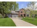 Lovely two-story red brick home with a gray roof and a long driveway at 839 Pebble Brook Pl, Noblesville, IN 46062