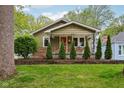 Charming home boasting an orange front door, manicured lawn, and fresh landscaping at 944 N Harbison Ave, Indianapolis, IN 46219