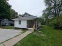 Side view of a cozy, single-story house featuring gravel and a landscaped lawn at 1009 Chestnut St, Anderson, IN 46012