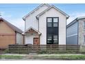 Modern two-story home with white siding, a dark window accent, and a rustic wood fence at 1009 Harrison St, Indianapolis, IN 46202