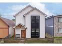 Modern two-story home with white siding, a dark window accent, and a rustic wood fence at 1009 Harrison St, Indianapolis, IN 46202
