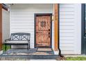 Close-up of a wooden front door with iron accents and a small porch with bench seating at 1009 Harrison St, Indianapolis, IN 46202