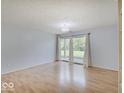 Open living space with sliding glass doors to the backyard, wood floors, and plenty of natural light at 1098 Timber Creek Dr # 2, Carmel, IN 46032