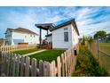 Modern home with a covered porch, fenced yard, and lush green lawn at 1112 Spann Ave, Indianapolis, IN 46203