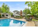 Stunning backyard retreat featuring a pool, outdoor kitchen, lounge area, and lush landscaping for ultimate relaxation at 11245 Old Stone Dr, Indianapolis, IN 46236