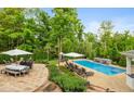 Backyard oasis with a pristine pool, lounge chairs, manicured landscaping, and outdoor dining area for entertaining at 11245 Old Stone Dr, Indianapolis, IN 46236