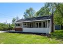 Quaint home featuring a screened front porch, brick accents, and a well-kept lawn, perfect for relaxing outdoors at 11600 N 100 E, Morristown, IN 46161