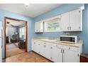 Bright kitchen featuring white cabinets and appliances, a practical layout, and an open view to the living room at 11600 N 100 E, Morristown, IN 46161