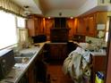Functional kitchen features wood cabinets, brick accents, and ample counter space at 1207 Van Buskirk Rd, Anderson, IN 46011