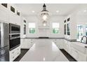 Bright kitchen featuring white cabinetry, a spacious island, modern stainless steel appliances, and pendant lighting at 12152 Teal Ln, Carmel, IN 46032