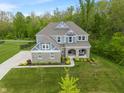 Stunning aerial view of a two-story home with stone accents and a spacious landscaped yard at 12811 Corydon Dr, Fishers, IN 46037