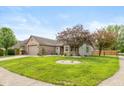 Lovely single-story home features brick accents, manicured lawn, and a two-car garage at 1283 Easton Point Dr, Greenwood, IN 46142