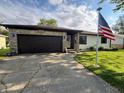 Charming single-story home with a stone and siding exterior, an attached garage, and a well-manicured lawn at 1513 Ashley Dr, Lebanon, IN 46052