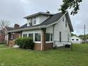 Charming home with white siding, well-maintained lawn, chain link fence and detached garage at 1618 California St, Columbus, IN 47201