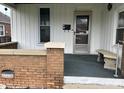 Close up of front porch featuring red brick accents, house number, and stone bench at 1618 California St, Columbus, IN 47201