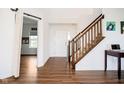 Bright entryway featuring wood floors, stairs with wooden railing, and a view into an adjacent room at 17951 Paula Walk, Westfield, IN 46074