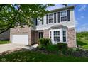 Well-maintained two-story home featuring a brick facade, bay window, and manicured landscaping at 1966 Freedom Ct, Greenfield, IN 46140