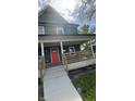 Stylish home featuring a covered porch, a bright red front door, and modern architectural details at 209 N Beville N Ave, Indianapolis, IN 46201