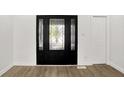 Elegant entryway featuring wood floors, decorative front door with sidelights and a white closet door at 213 S State Ave, Indianapolis, IN 46201