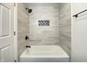 Newly renovated bathroom showcasing a tiled shower/tub combo and a convenient storage niche at 2141 Napoleon St, Indianapolis, IN 46203