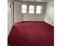 Spacious bedroom featuring three windows, red carpet flooring, and natural light at 2621 N Tacoma Ave, Indianapolis, IN 46218