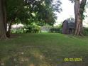 Spacious backyard with mature trees, grassy area, and a shed at 3049 S Rybolt Ave, Indianapolis, IN 46241
