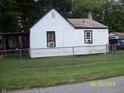 Side view of a white home with black trim, windows and a chain link fence at 3057 S Rybolt Ave, Indianapolis, IN 46241