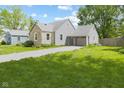 View of house, detached garage, driveway, and grassy yard at 311 Duffey St, Plainfield, IN 46168