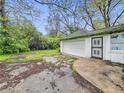 Detached garage featuring a white exterior, side window, and black iron security door at 3516 Janet Dr, Indianapolis, IN 46218