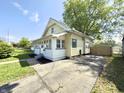 Charming two-story home with a quaint porch, a long driveway, and a detached garage at 417 S Oakland Ave, Indianapolis, IN 46201