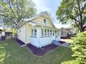 Charming two-story home with a quaint porch, a well-maintained lawn, and mature trees at 417 S Oakland Ave, Indianapolis, IN 46201
