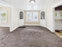 Open-concept living room featuring built-in display cabinets and plush carpeting at 510 E 23Rd St, Anderson, IN 46016