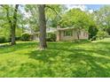 A beautifully landscaped ranch style home with a well-manicured lawn and mature trees offering plenty of shade at 5648 Rolling Ridge Rd, Indianapolis, IN 46220