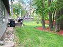 Expansive backyard featuring deck, green grass, and mature trees, perfect for relaxing and entertaining at 569 Meadow Dr, Danville, IN 46122